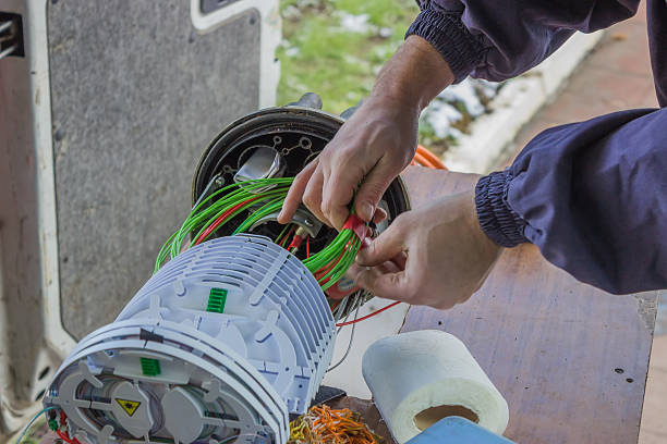 Mauritz Satellite Services technician meticulously arranging rolls of fibre-optic cables within a splice organiser tray, showcasing precision and expertise in fiber-optic installations.