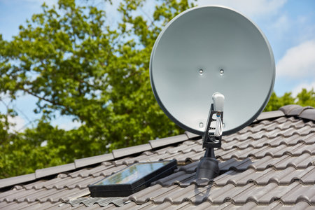 Modern satellite dish mounted on a roof for TV reception.